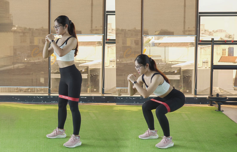 Squat với dây kháng lực tăng cường sức mạnh cơ đùi, cơ mông và cơ bắp chân, tăng cường độ dẻo dai và khả năng vận động của khớp hông.